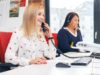 Two women talking to customers on the phone