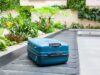 Suitcase On A Conveyor Belt Surrounded By Green Tropical Plants