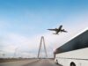 Bus driving towards a bridge and following a plane